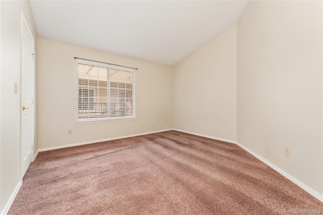 carpeted spare room featuring vaulted ceiling