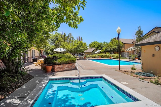 view of pool featuring an in ground hot tub and a patio area