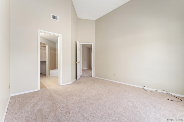8623 E Dry Creek Rd Unit 423, Englewood, CO 80112 - unfurnished bedroom featuring light carpet, a towering ceiling, and a walk in closet