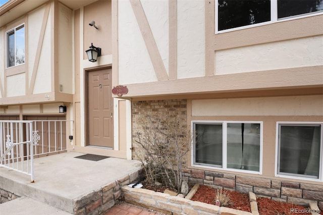 property entrance with stone siding and stucco siding