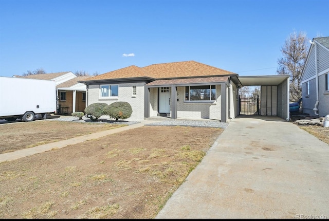 view of front of house with concrete driveway, brick siding, and roof with shingles