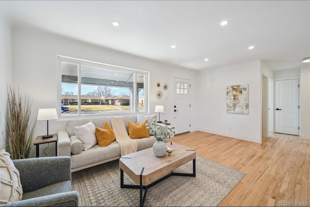 living room with light wood finished floors, recessed lighting, and baseboards