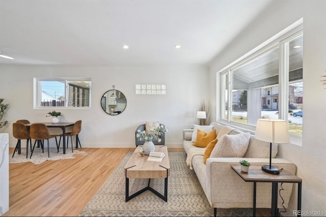 living area featuring recessed lighting, plenty of natural light, wood finished floors, and baseboards