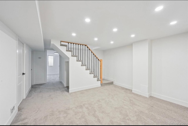 finished basement featuring stairway, recessed lighting, baseboards, and light carpet