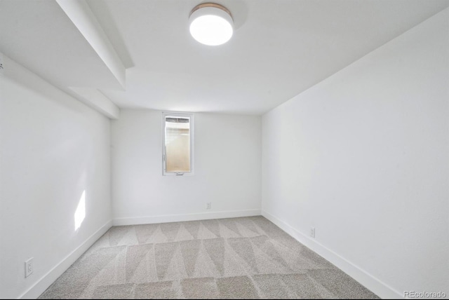 unfurnished room with baseboards and light carpet