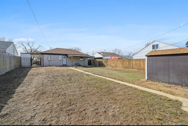 view of yard with a storage shed, an outdoor structure, and a fenced backyard