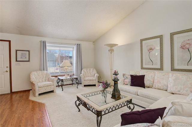 living room with hardwood / wood-style floors, a textured ceiling, and vaulted ceiling