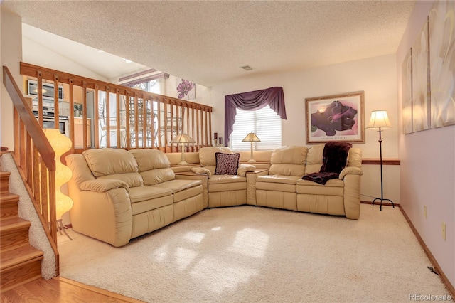 living room featuring hardwood / wood-style flooring, a textured ceiling, and lofted ceiling