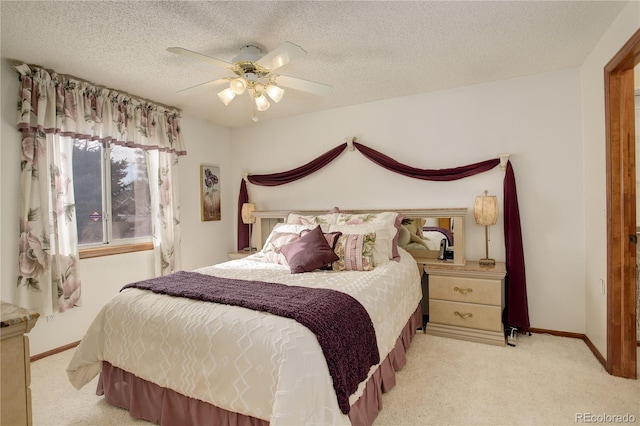 bedroom with a textured ceiling, ceiling fan, and light colored carpet