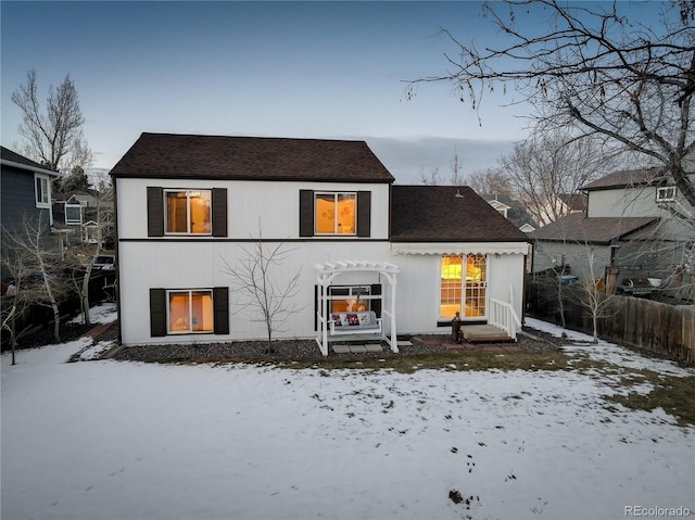 view of snow covered back of property