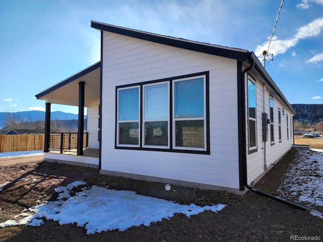 view of snow covered exterior featuring covered porch and a mountain view