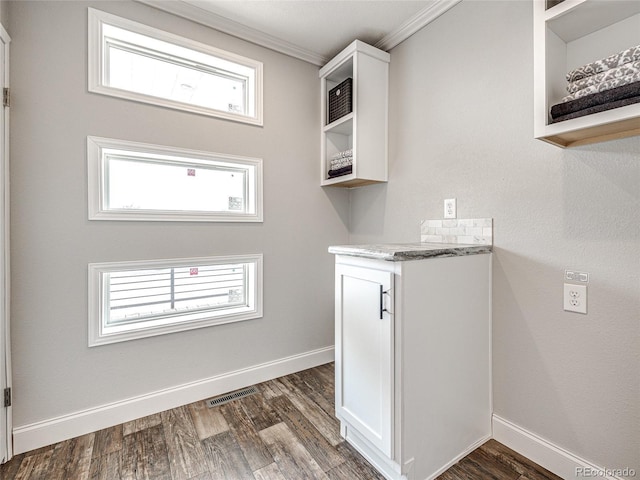 laundry room featuring ornamental molding and dark hardwood / wood-style flooring