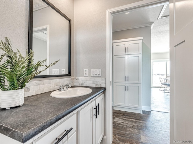 bathroom featuring ornamental molding, wood-type flooring, and vanity