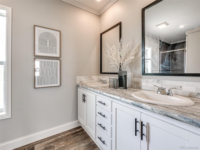 bathroom with hardwood / wood-style floors, crown molding, vanity, plenty of natural light, and a shower with shower door