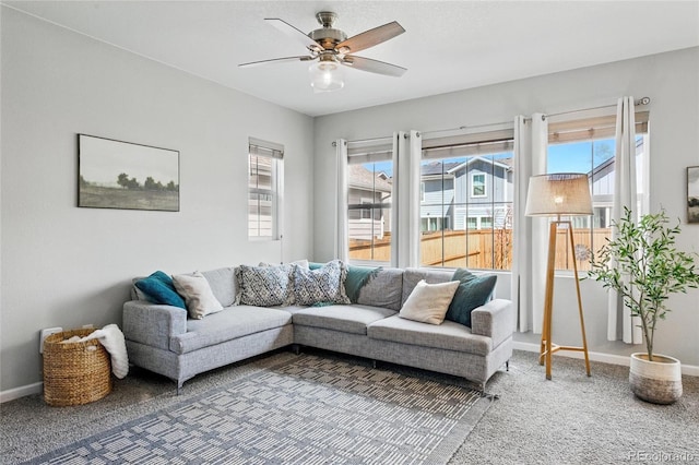 carpeted living area featuring baseboards and ceiling fan