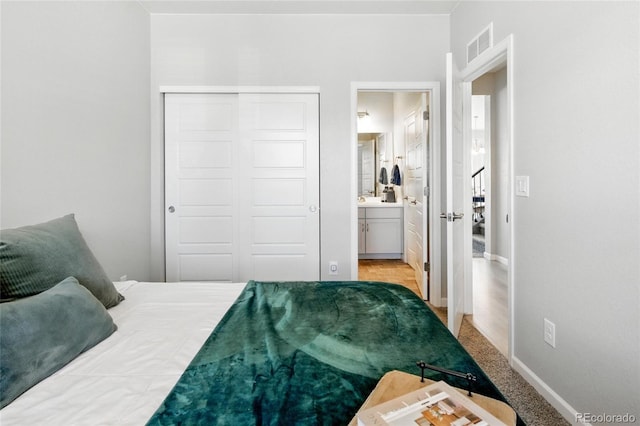 bedroom with visible vents, connected bathroom, baseboards, and a closet