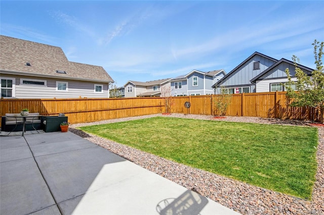 view of yard with a patio, a fenced backyard, and a residential view