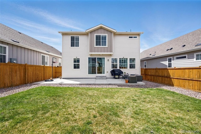 back of house featuring a fenced backyard, a yard, and a patio area