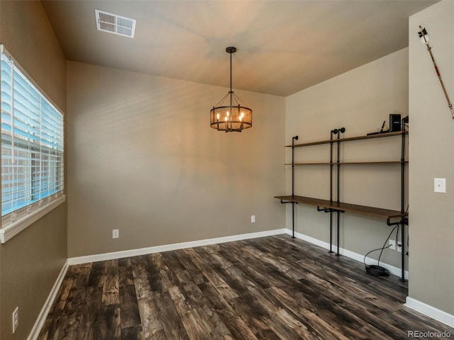 unfurnished room with dark hardwood / wood-style flooring and a notable chandelier