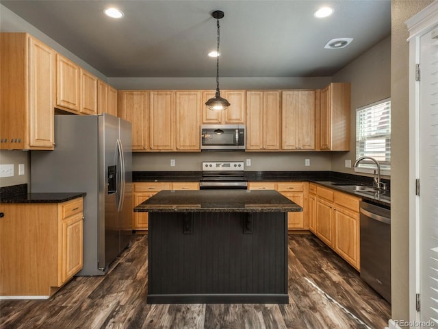 kitchen featuring pendant lighting, a center island, sink, appliances with stainless steel finishes, and dark hardwood / wood-style flooring