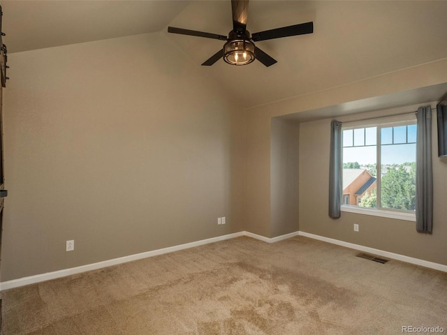 spare room featuring ceiling fan, lofted ceiling, and light carpet