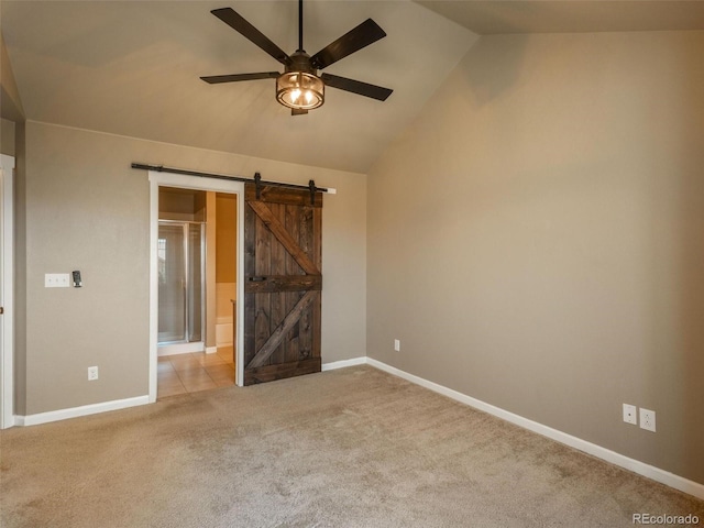 carpeted empty room with a barn door, ceiling fan, and lofted ceiling