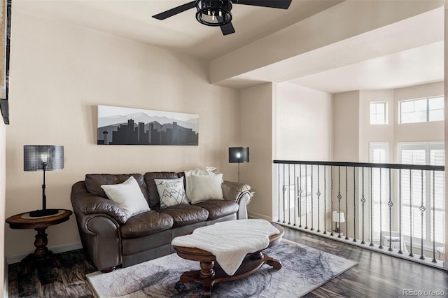 living room featuring ceiling fan and dark hardwood / wood-style flooring