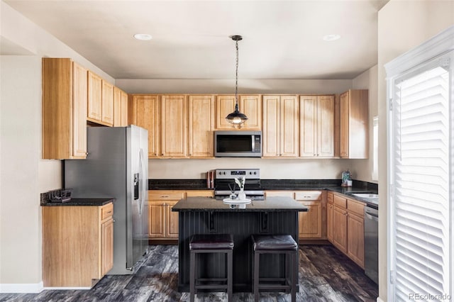 kitchen with pendant lighting, a kitchen island, stainless steel appliances, a kitchen bar, and dark hardwood / wood-style flooring