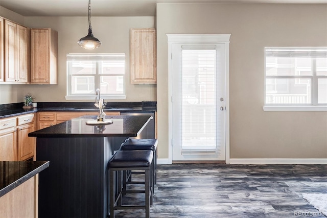 kitchen with sink, a breakfast bar, a healthy amount of sunlight, and a kitchen island