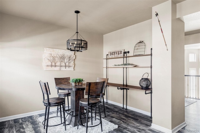 dining area with dark hardwood / wood-style floors and a chandelier