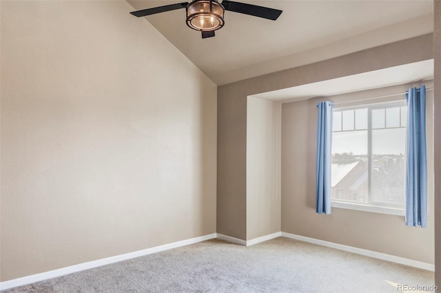 empty room with ceiling fan, vaulted ceiling, and light carpet