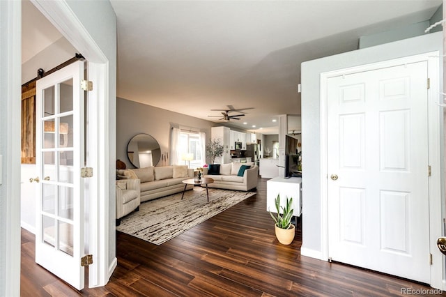 22026 Hill Gail Way, Parker, CO 80138 - living room featuring dark wood-style flooring, ceiling fan, and a barn door