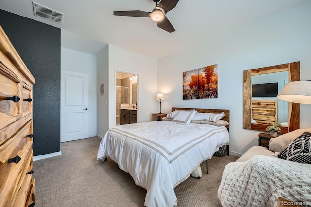 carpeted bedroom featuring baseboards, connected bathroom, visible vents, and a ceiling fan