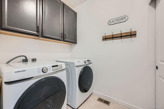 clothes washing area featuring baseboards, independent washer and dryer, visible vents, and cabinet space