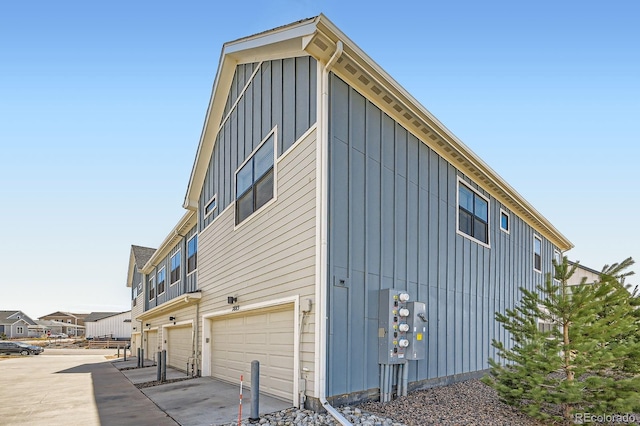 view of side of home featuring driveway, a garage, and board and batten siding
