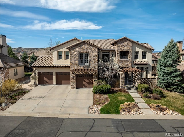 mediterranean / spanish house with concrete driveway, stone siding, a tiled roof, an attached garage, and stucco siding