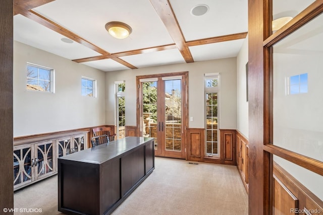 office with coffered ceiling, visible vents, light carpet, beam ceiling, and wainscoting