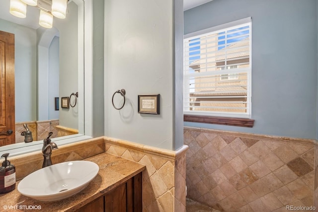 bathroom with tile walls, wainscoting, and vanity