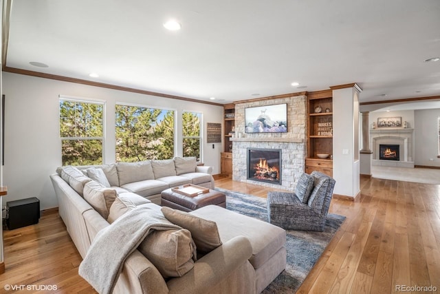 living room featuring a fireplace, crown molding, and recessed lighting