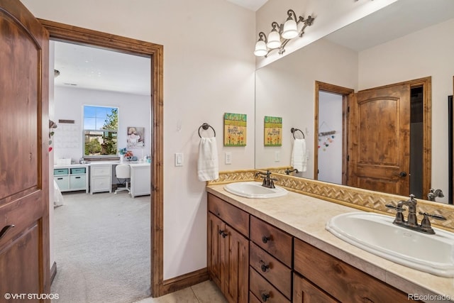 bathroom featuring double vanity, baseboards, and a sink