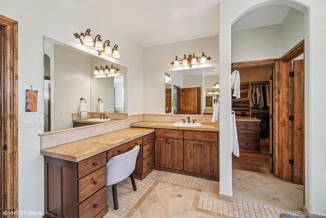 full bathroom featuring a spacious closet, vanity, and tile patterned floors