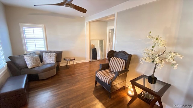 sitting room with a ceiling fan, wood finished floors, and baseboards