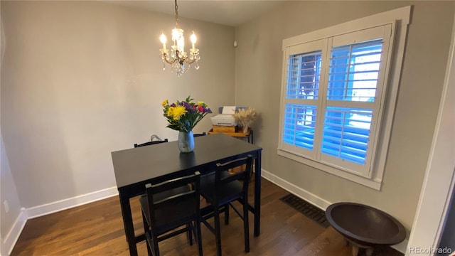 dining room featuring visible vents, baseboards, dark wood-type flooring, and a chandelier