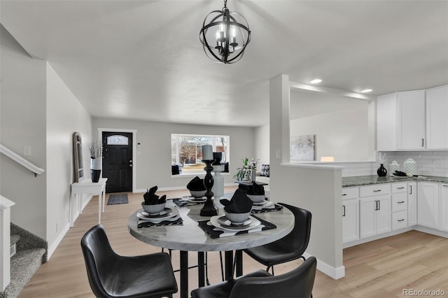 dining space with an inviting chandelier and light wood-type flooring