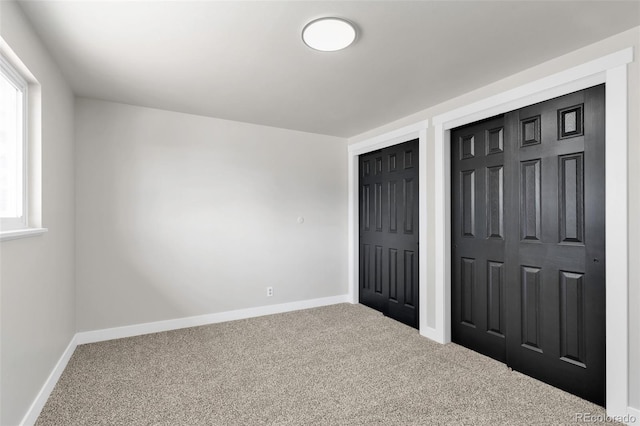 unfurnished bedroom with carpet and two closets