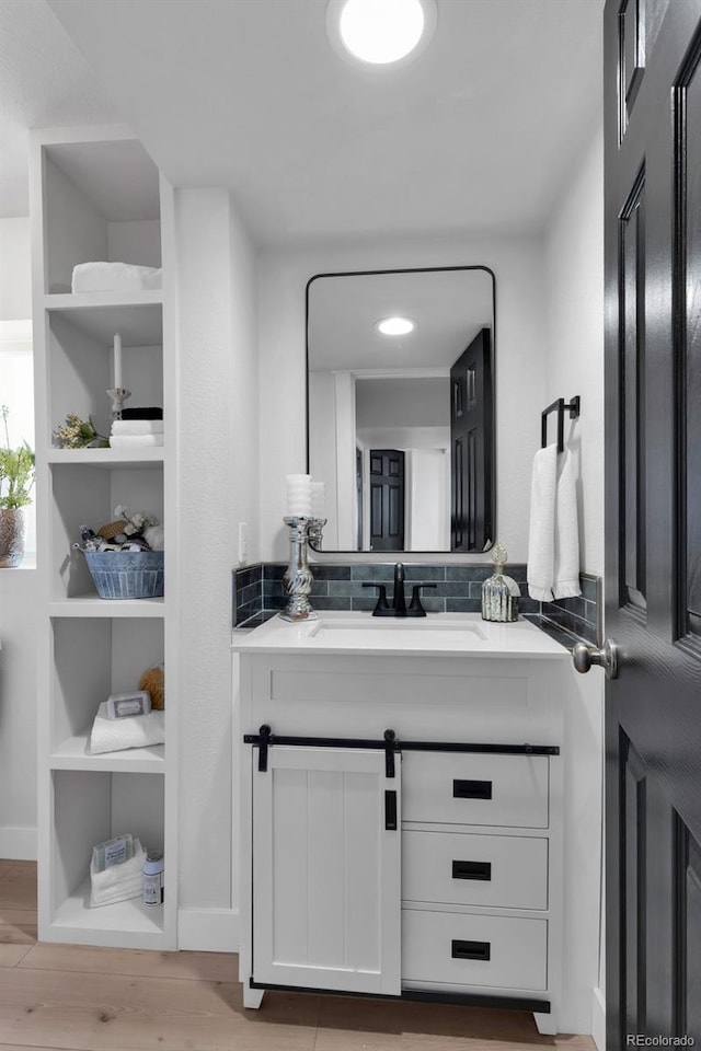 bathroom with vanity, wood-type flooring, and backsplash