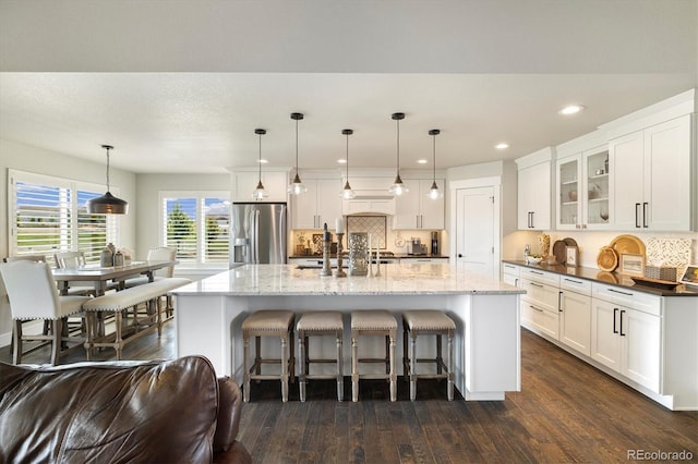 kitchen featuring stainless steel fridge, tasteful backsplash, dark wood-style floors, glass insert cabinets, and recessed lighting
