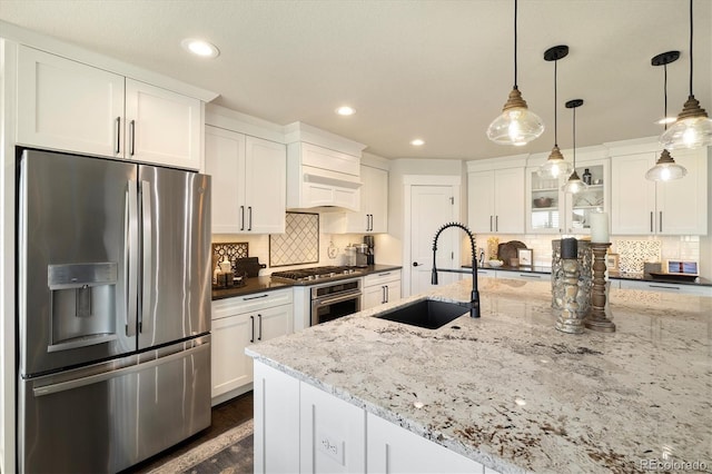 kitchen with stainless steel appliances, a sink, white cabinets, decorative backsplash, and recessed lighting