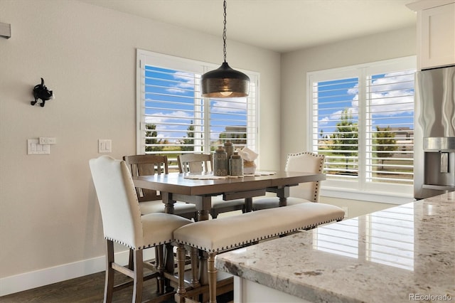 dining space with baseboards, dark wood-style flooring, and healthy amount of natural light