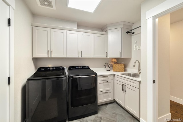laundry area featuring washing machine and dryer, cabinet space, and baseboards